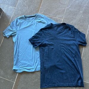 Two mens Lululemon short sleeve shirts size small, light blue and dark blue.